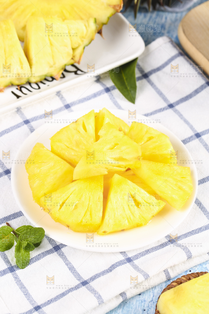 格子布上放着一盘凤梨果肉