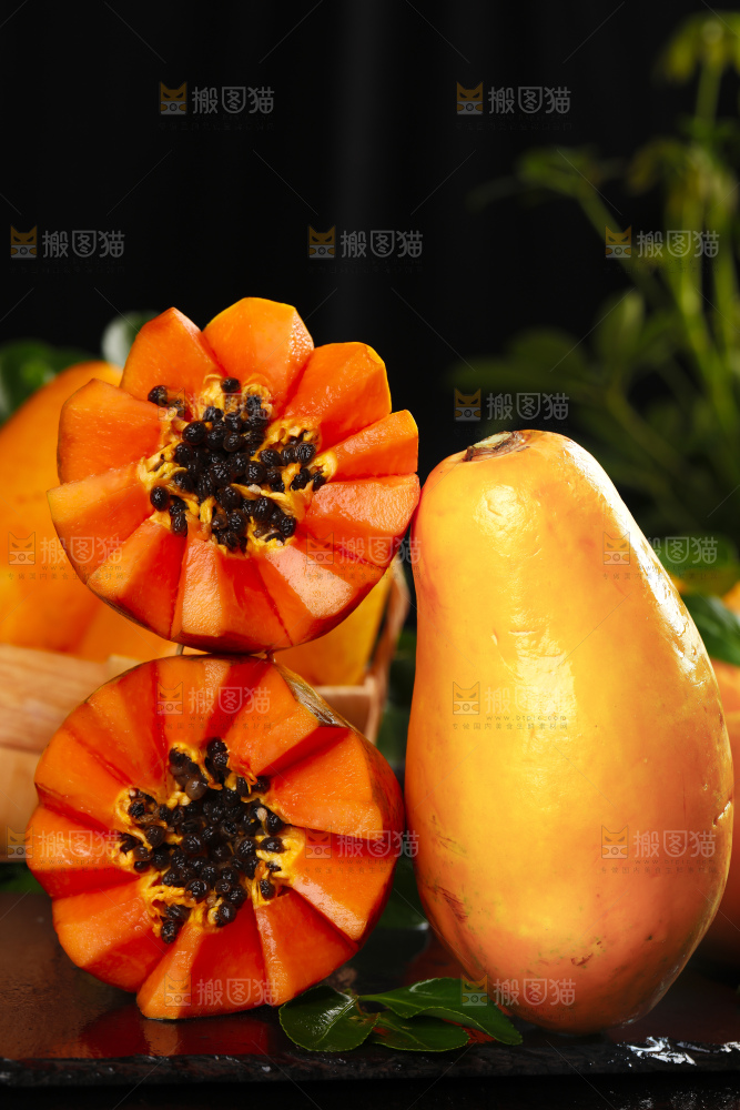 黑底上放着切开的牛奶红心木瓜