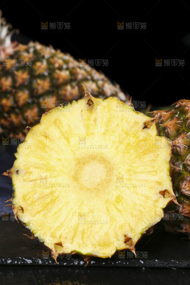 黑石板上放着切开的新鲜凤梨