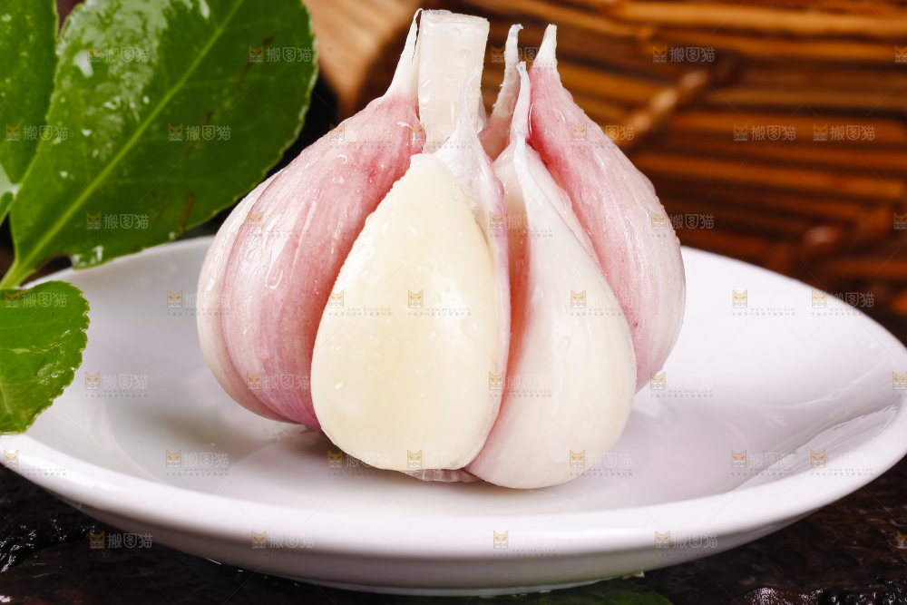 一盘山东紫皮大蒜放在黑底上