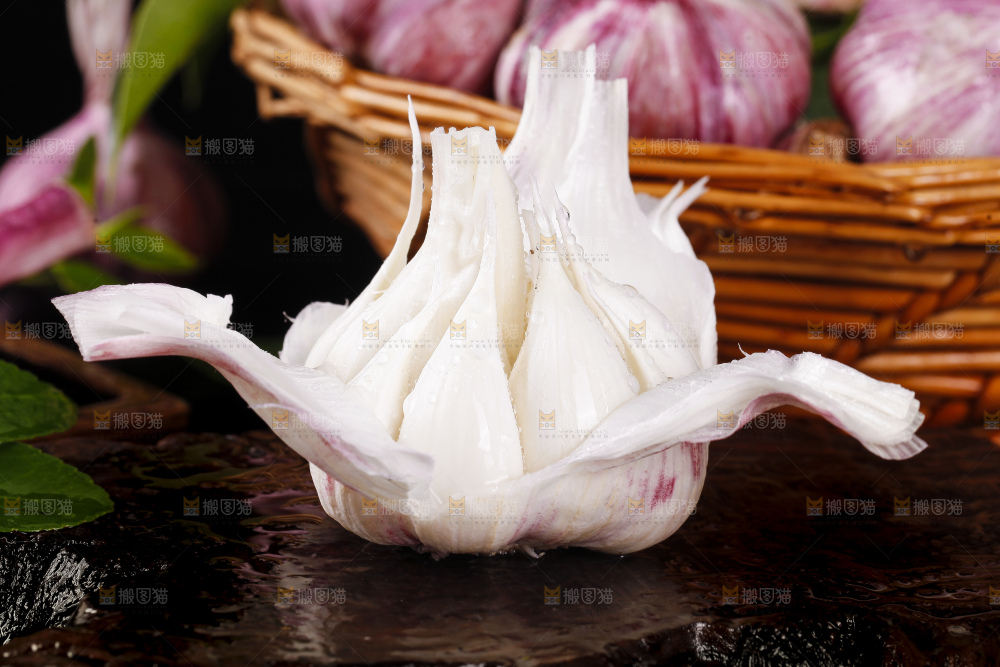 黑底上放着剥皮的新鲜紫皮大蒜