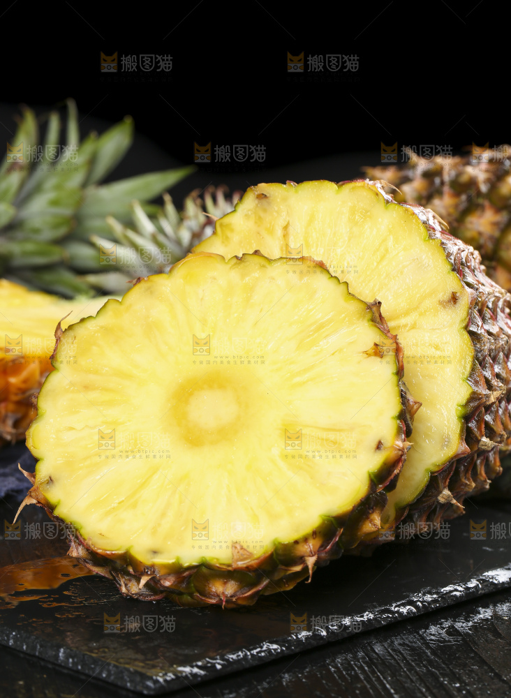 黑石板上放着切开的新鲜凤梨
