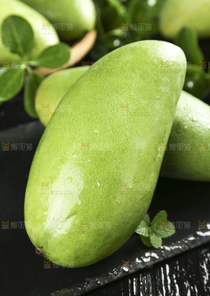 黑底上放着新鲜青皮芒果