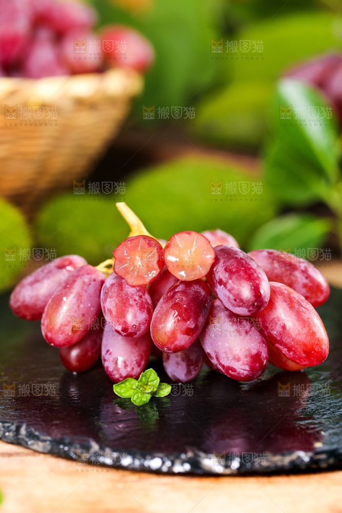 黑石板上放着切开的美人指葡萄