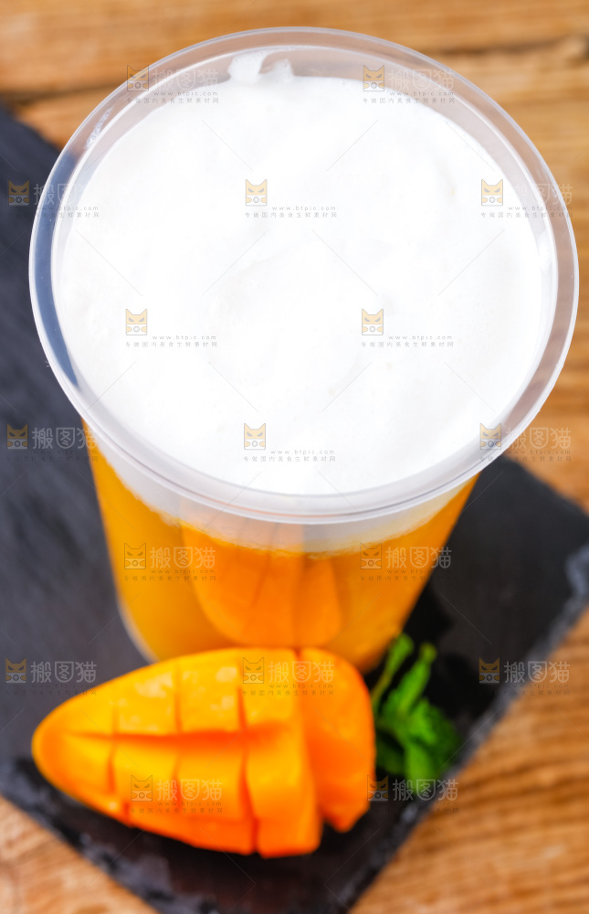 黑石板上放着一杯芒果果汁