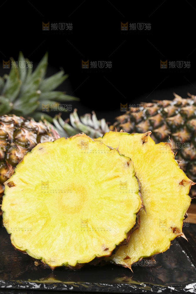 黑石板上放着切开的新鲜凤梨
