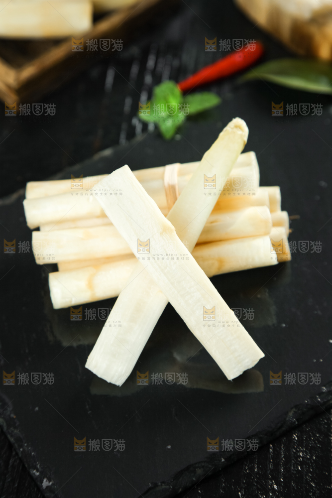 黑石板上放着切开的白芦笋