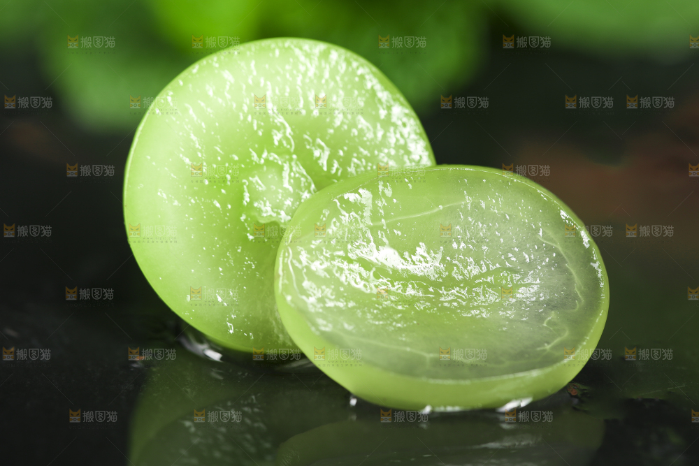 黑石垫上放着切开的无籽青提