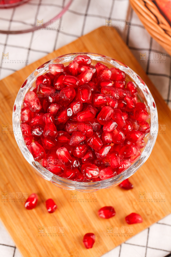 木板上放着一碗石榴果肉