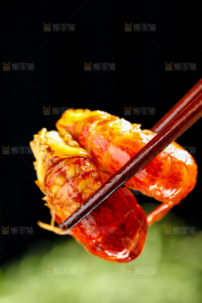 筷子夹着龙虾尾