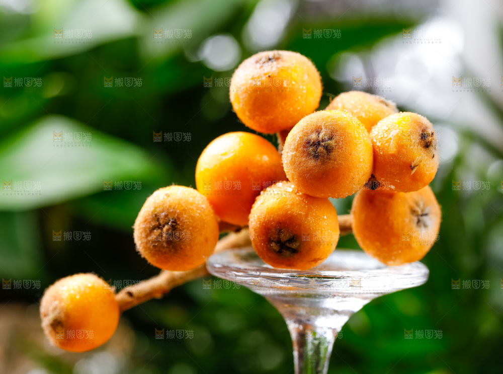 玻璃杯上放着枇杷