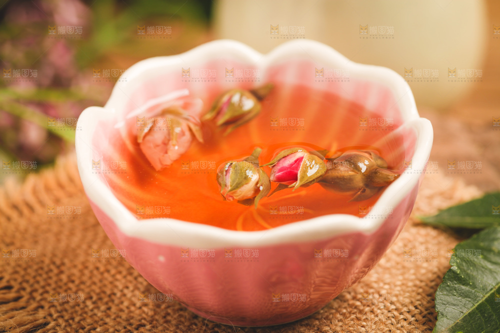 竹编上放着一盏玫瑰花茶
