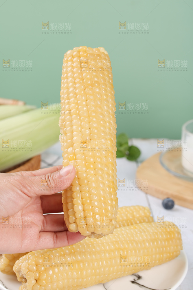 手里拿着白糯玉米棒