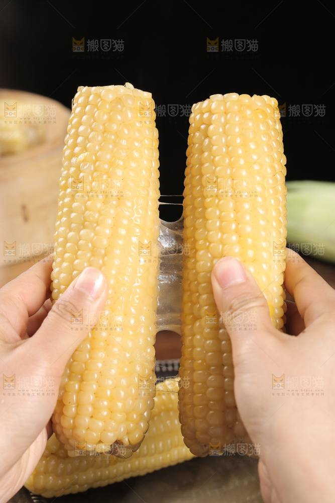 手里拿着白糯玉米棒