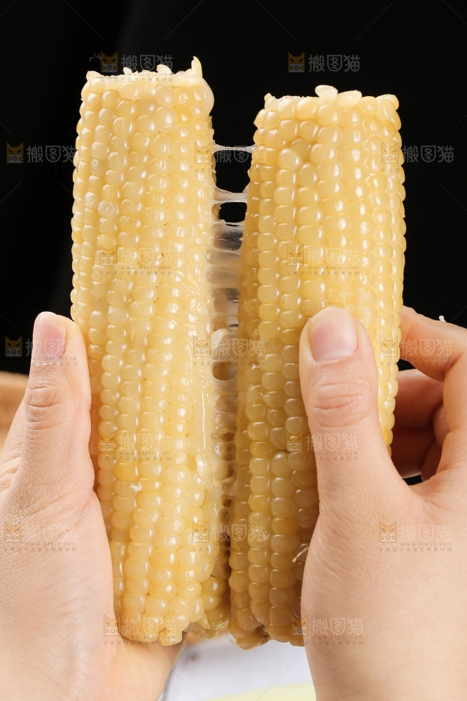 手里拿着白糯玉米棒