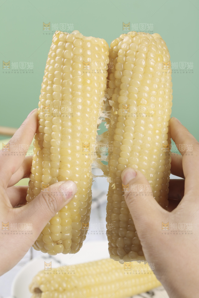 手里拿着白糯玉米棒