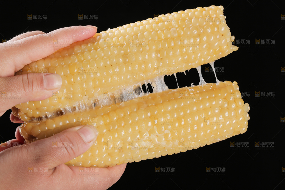 手里拿着白糯玉米棒