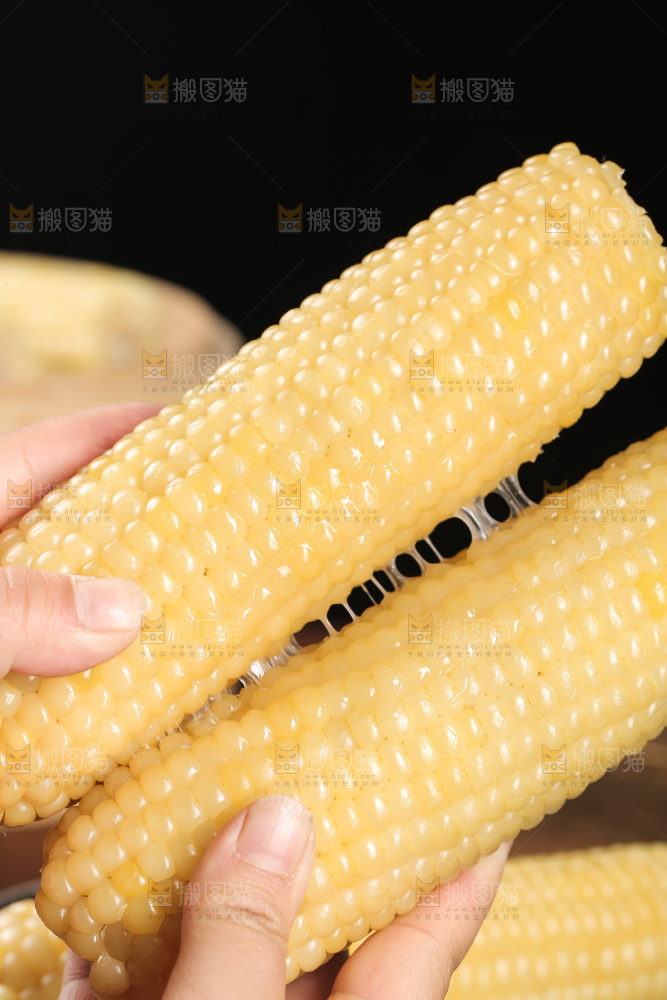手里拿着白糯玉米棒