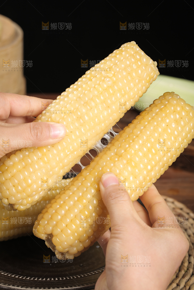 手里拿着白糯玉米棒