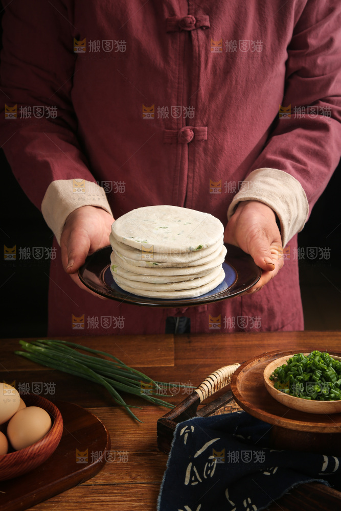 手里端着一盘葱油饼