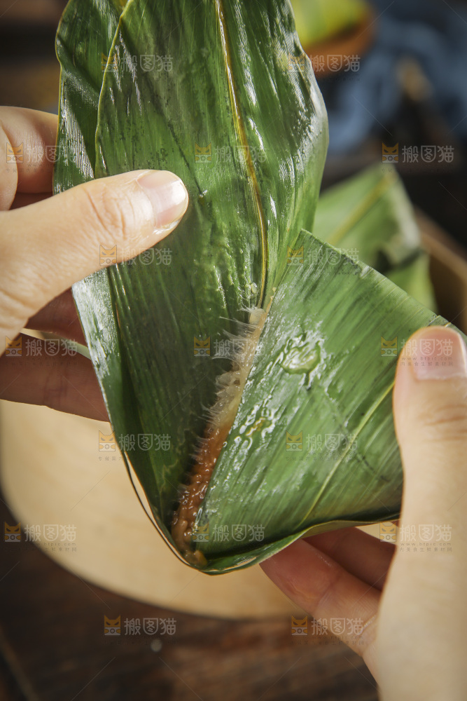 手里剥着粽子