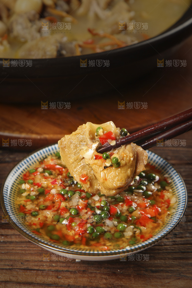 筷子上夹着蘸酱的鸡肉