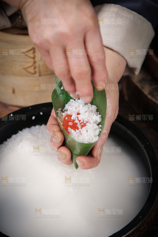 手里包着蛋黄粽子