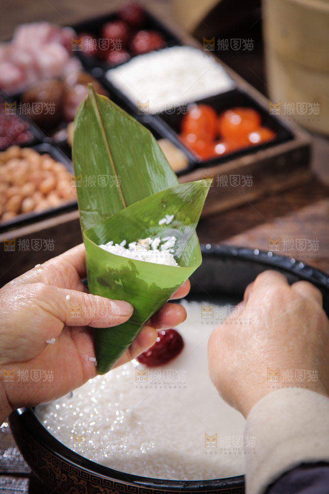 手里包着端午节粽子