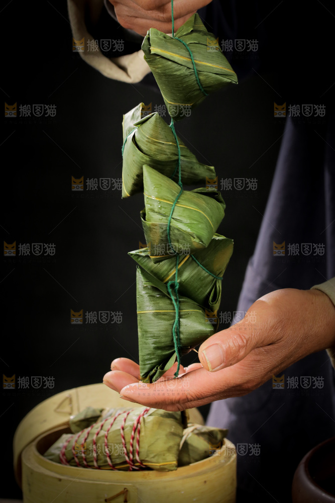 手里提着新鲜粽子