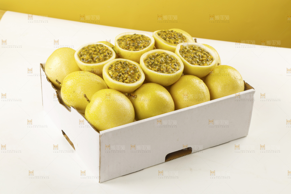 白底上摆放着一箱新鲜黄金百香果