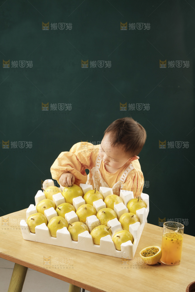 小孩面前桌子摆放着一箱黄金百香果