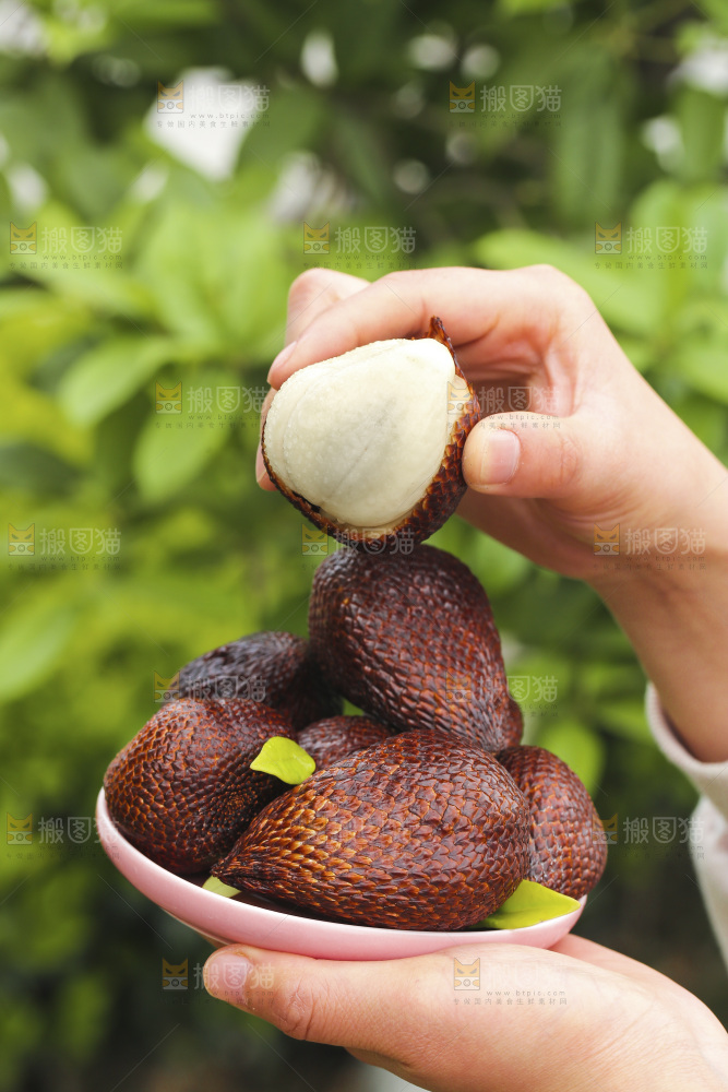 手里端着一盘蛇皮果