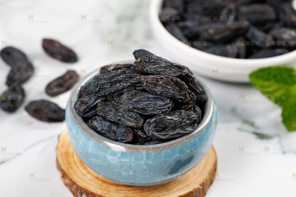 木板上放着一碗黑葡萄干