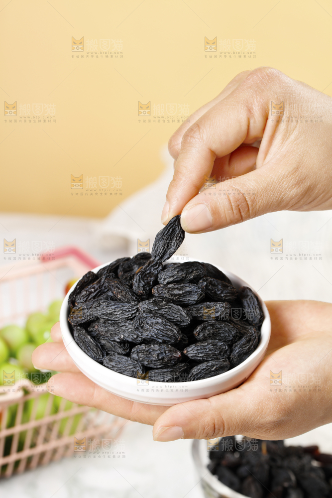 手里端着一盘黑加仑葡萄干