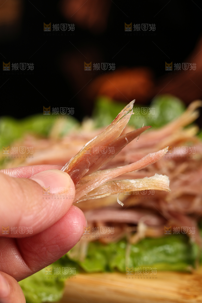 手里拿着撕开的鸡肉