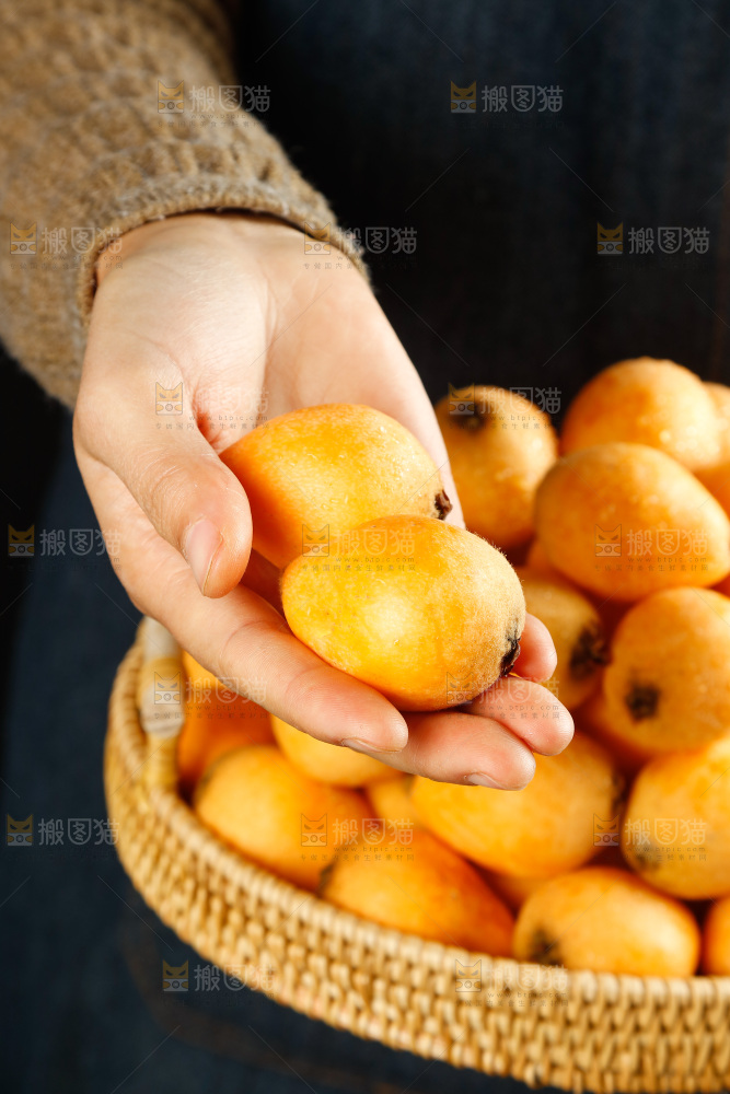 手里拿着枇杷