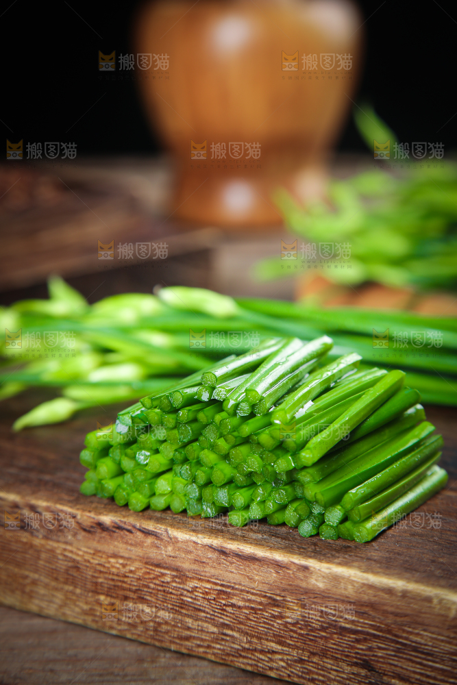 木板上放着切开的韭苔