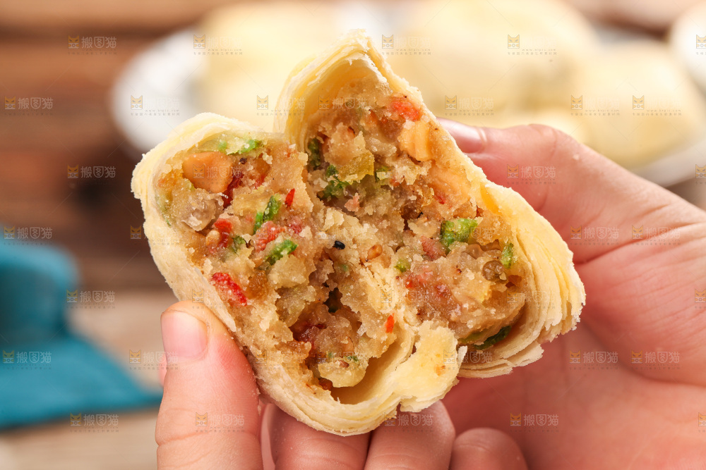 手拿着掰开的酥皮月饼