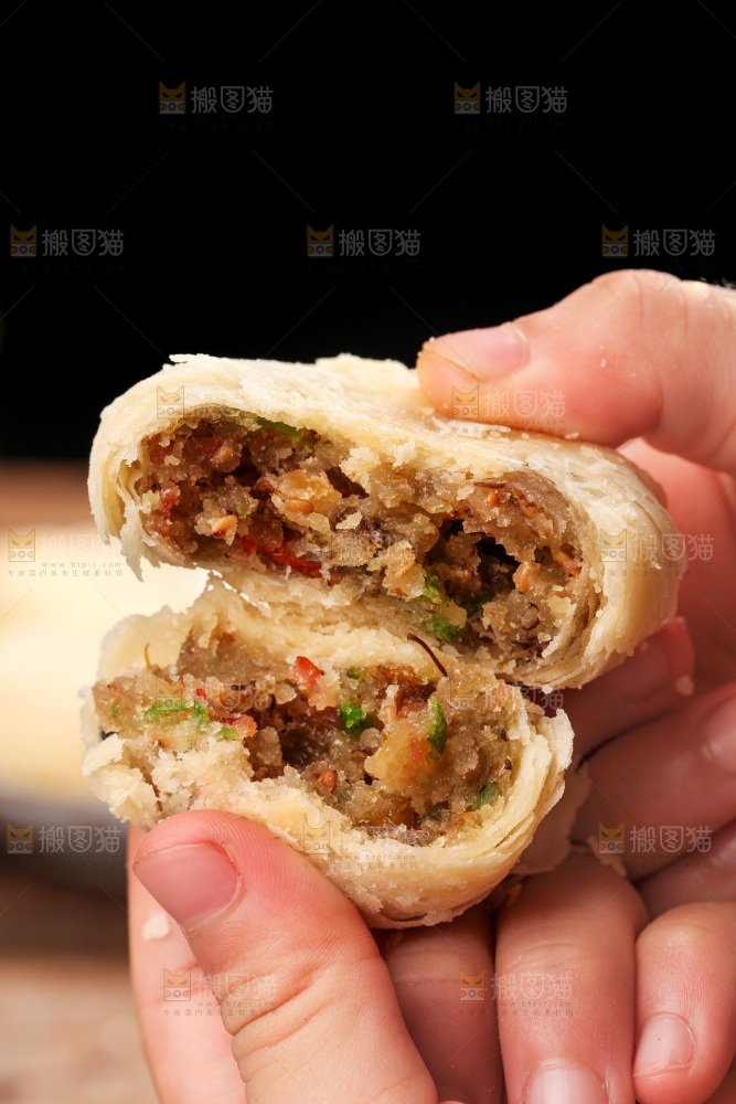 手拿着掰开的酥皮月饼