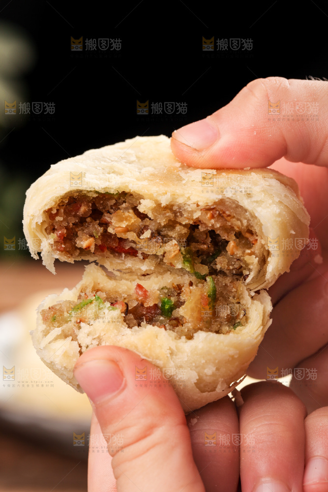手拿着掰开的酥皮月饼