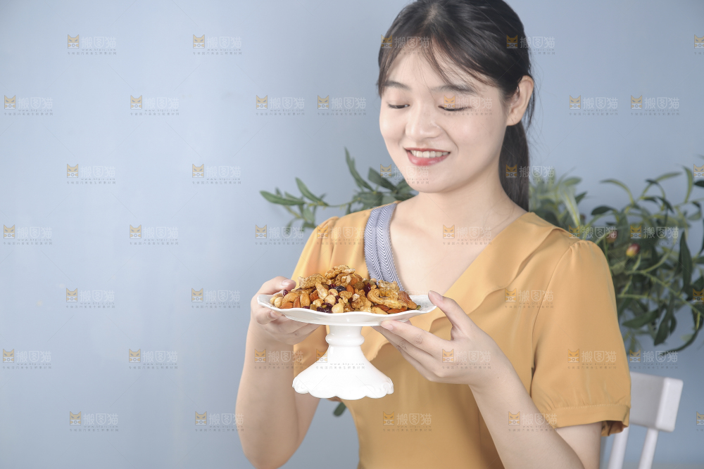 女孩手上端着一盘坚果组合
