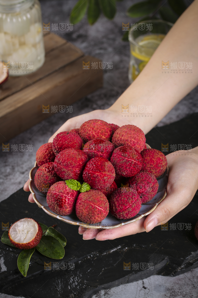 手上捧着一盘无核荔枝