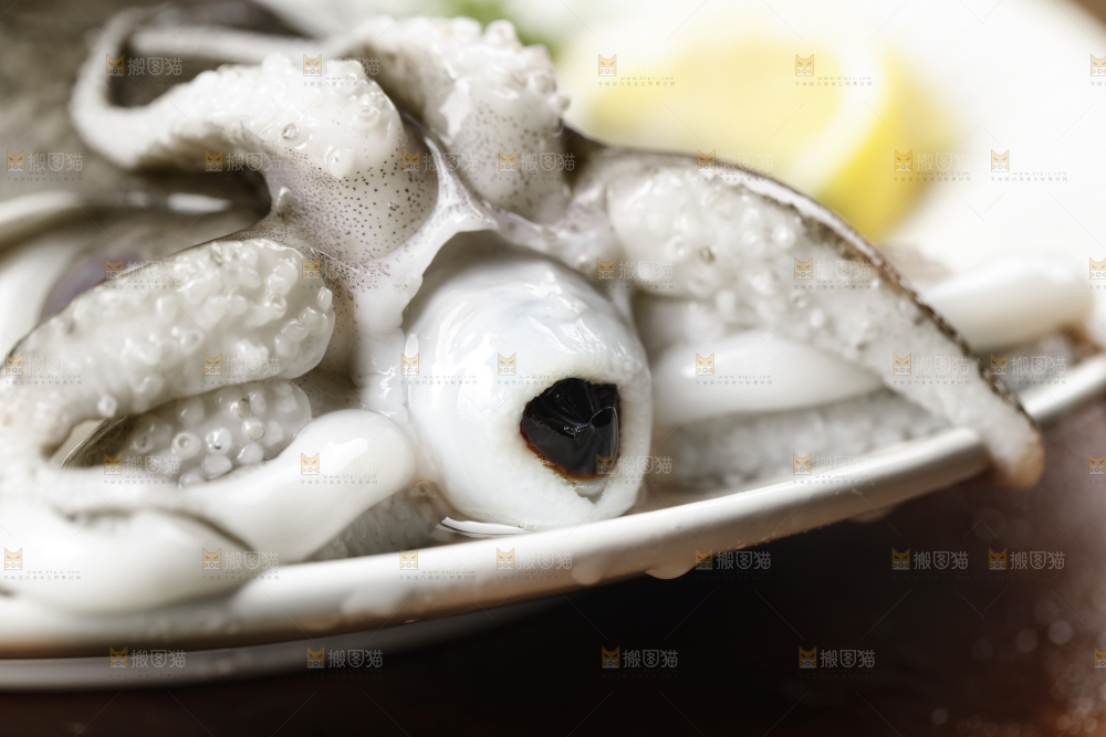 木板上放着一盘北海墨鱼