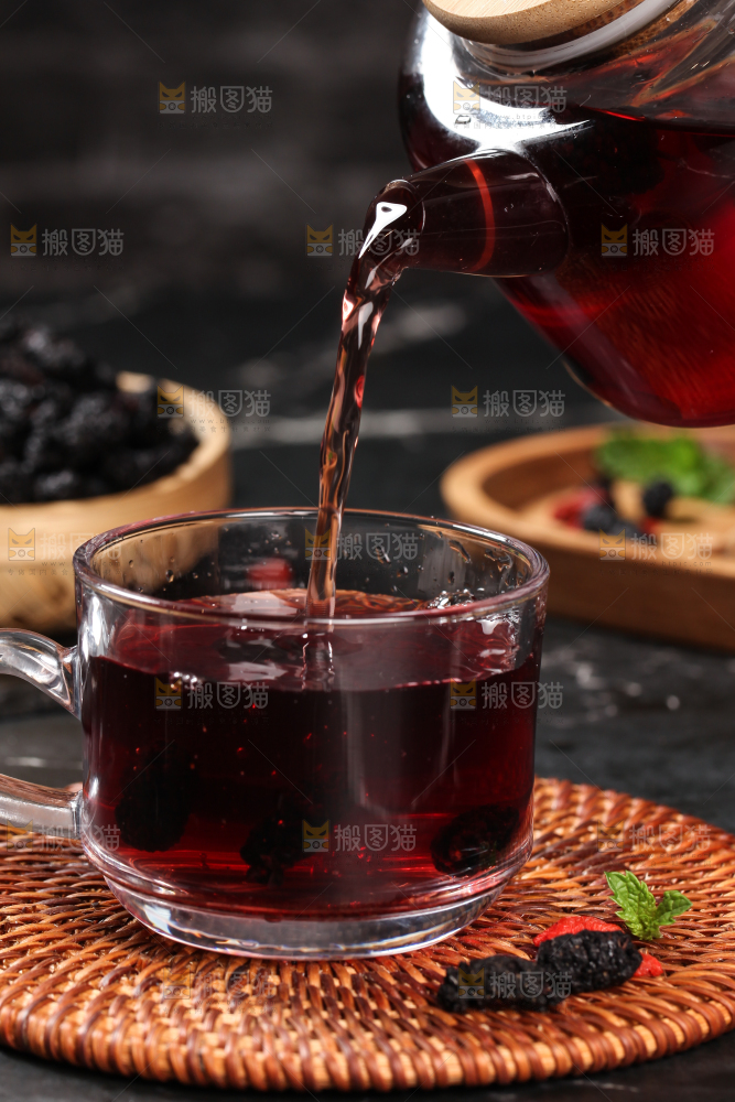 木垫上放着一杯桑葚干泡水
