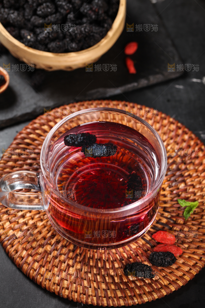 木垫上放着一杯桑葚干泡水