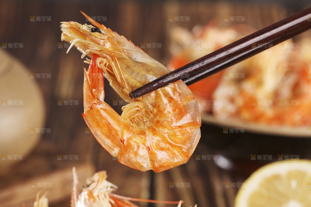 筷子上夹着碳烤虾