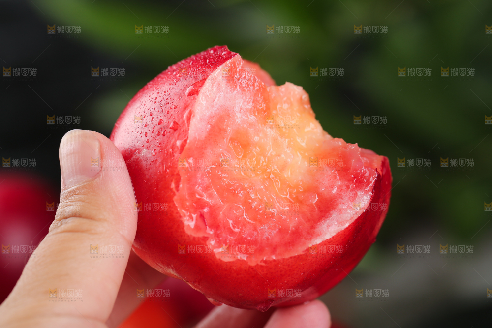 手上拿着红肉油桃