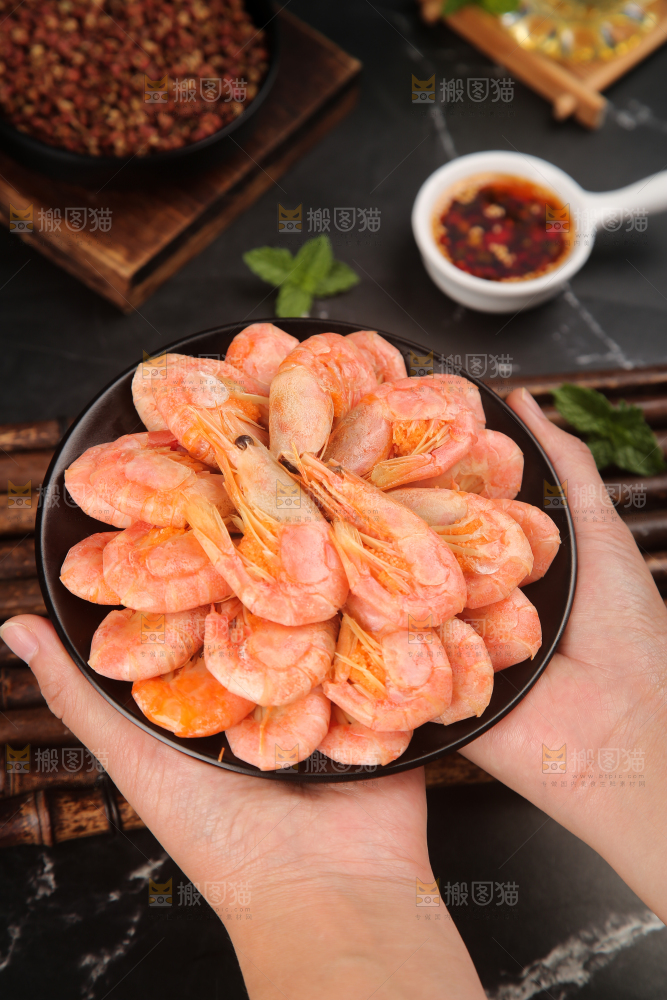 手上端着一盘甜虾