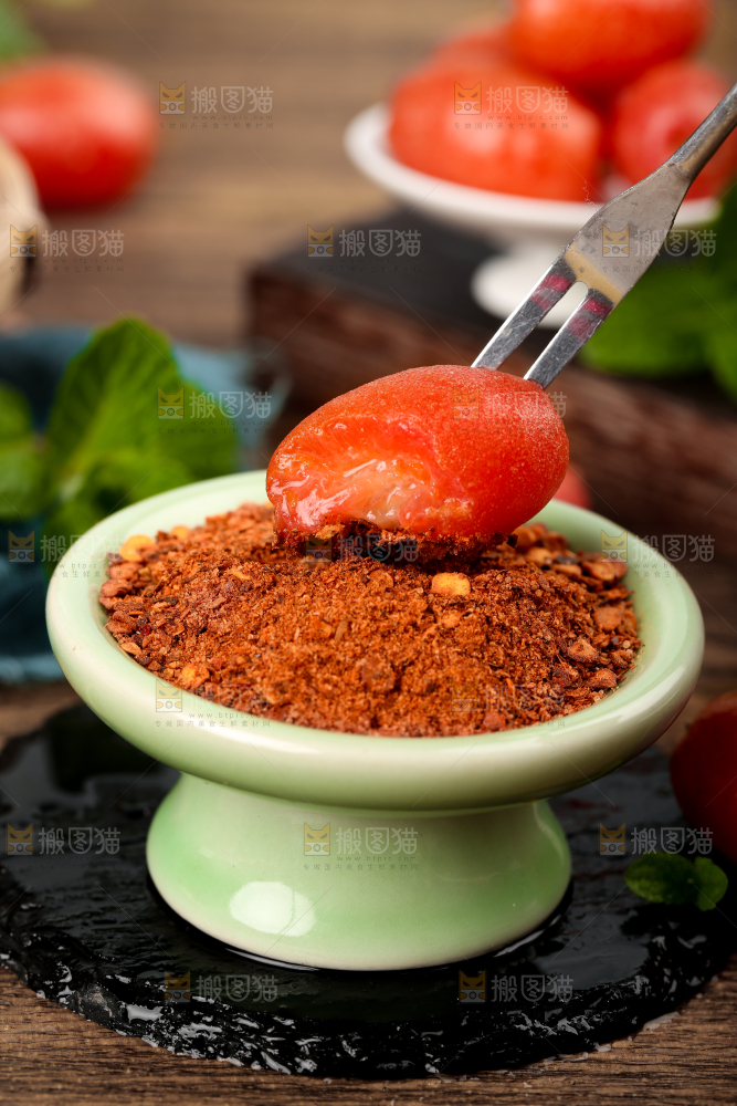 叉子插着蘸辣椒粉的羊奶果