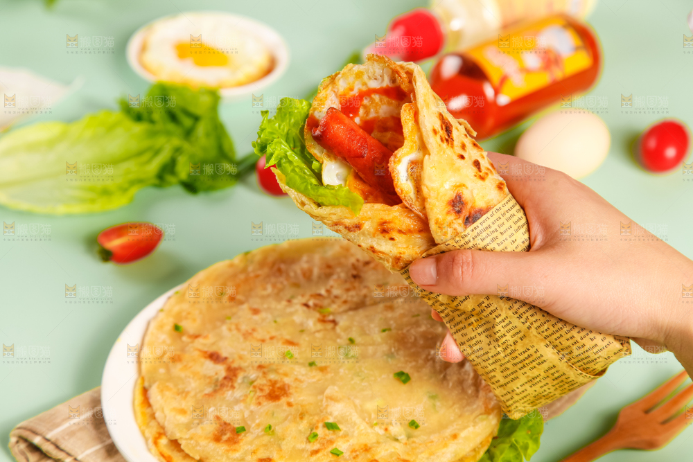 手拿着手抓饼卷